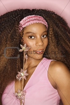 Young African-American woman holding flower.