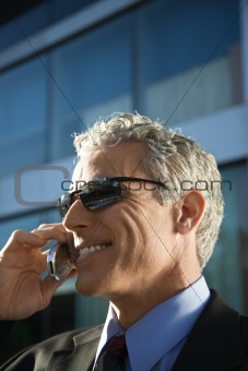 Businessman talking on cellphone in urban setting.