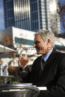 Businessman drinking water at table.