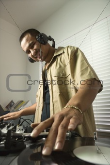 Male DJ with hands on record.
