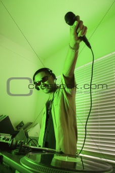 Male DJ holding mic in air.