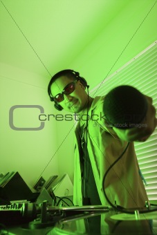 Male DJ holding mic towards viewer.