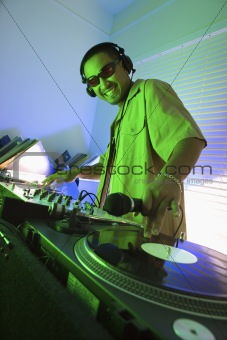 Male DJ with hand on record.