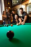 Group of young adults playing pool.