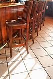 Bar stools lined up at bar.