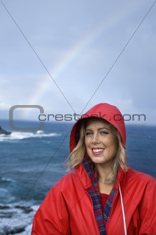 Woman by ocean and rainbow in Maui, Hawaii.