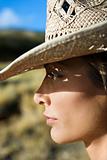 Young woman wearing a straw cowboy hat.