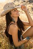 Young woman wearing a straw cowboy hat.