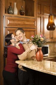 Man arranging flowers while being kissed.