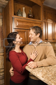 Man and woman looking at each other in kitchen.