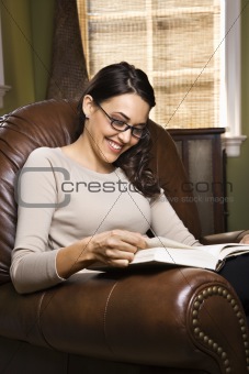 Woman sitting in chair reading.