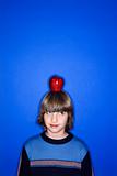 Caucasian boy with apple on his head.
