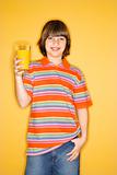 Caucasian boy holding glass of orange juice.
