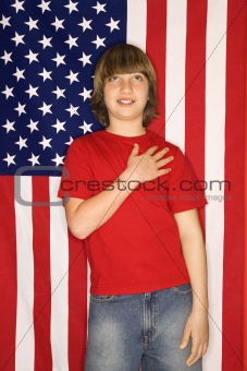 Caucasian boy with hand over heart with american flag background