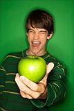 Caucasian teen boy holding apple.
