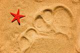 Toes trace on sand and red star