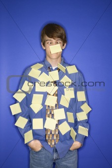 Caucasian teen boy covered with sticky notes.