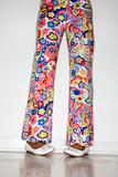 African-American teen girl's legs with floral pants and white sh
