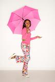 African-American teen girl holding a pink umbrella. 