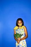 African-American teen girl holding daisies.