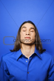 Asian-American teen boy with eyes closed.