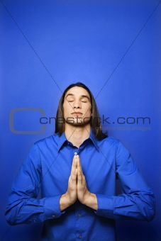 Asian-American teen boy meditating.