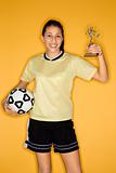 Multi-racial teen girl holding soccer ball and trophy.