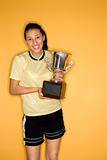 Multi-racial teen girl holding trophy.