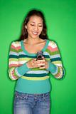 Multi-racial teen girl dialing cellphone.