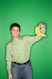 Caucasian teen boy holding bananas.