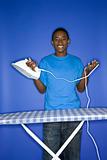 African-American teen boy doing ironing.