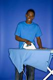 African-American teen boy ironing.