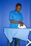 African-American teen boy ironing.