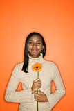 African-American teen girl holding daisy.