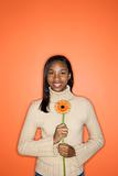 African-American teen girl holding flower.