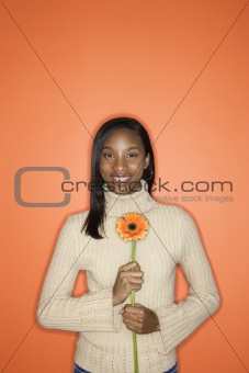 African-American teen girl holding flower.