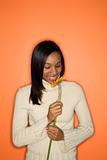African-American teen girl smelling flower.