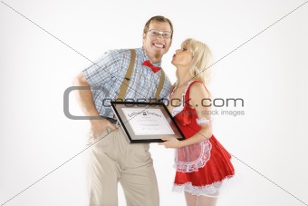 Young man receiving kiss and certificate from young woman.
