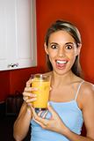 Young woman holding a glass of orange juice.