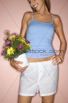 Woman holding pot of flowers.