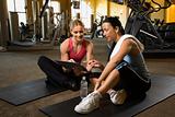Adult female with personal trainer at gym.