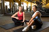 Prime adult Caucasian female with personal trainer at gym.