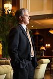 Businessman standing in hotel lobby.