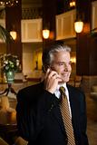 Businessman talking on cellphone in hotel lobby.