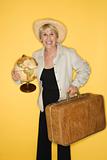 Woman holding suitcase and globe.