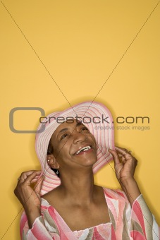 Woman holding her hat.