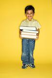 Boy holding stack of books.