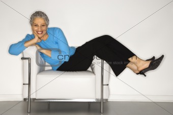 Woman lying back on chair.