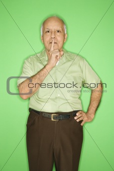 Man with finger up to mouth.