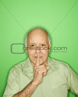 Man holding finger to mouth.